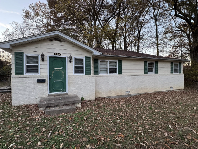 Tennessee house before work: dated cream siding, green shutters, bare concrete steps